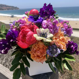Colorful bouquet of mixed flowers in a white container
