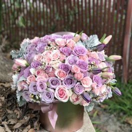 Lavender and pink rose bouquet in a round hatbox with ribbon