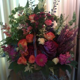 Large mixed flower arrangement in a wicker basket