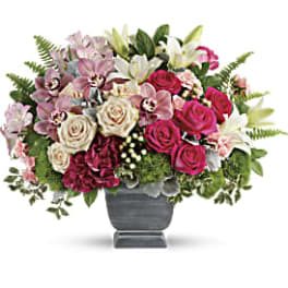 Mixed pink and white floral arrangement in a gray vase