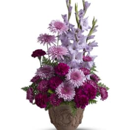 Purple and pink mixed flower arrangement in a decorative pot
