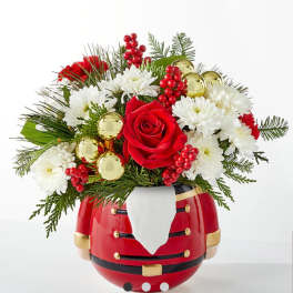 Christmas bouquet in a Santa-shaped vase with red and white flowers