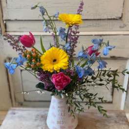 Mixed bouquet in a white vase with yellow daisies and pink tulips