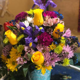 Colorful mixed bouquet in a turquoise tin container