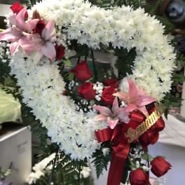 Heart-shaped floral wreath with white chrysanthemums, red roses, and pink lilies