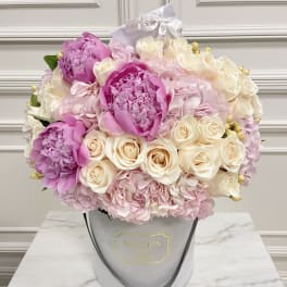 Pink and cream bouquet in a gray hatbox with ribbon