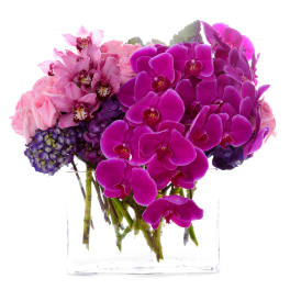 Pink and purple orchid bouquet in a clear glass vase