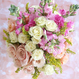 Bouquet of pink and cream roses with small pink blooms