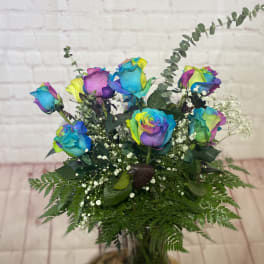 Bouquet of rainbow-colored roses in a glass vase