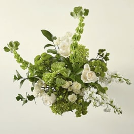 Green and white floral arrangement with roses and tall spiky blooms