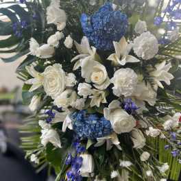 Tall bouquet of white flowers with blue hydrangeas and purple accents