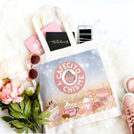 Gift tote with notebooks, phone, sunglasses, flowers, and pink sneakers