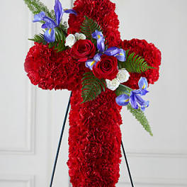 Red floral cross on a stand with roses and blue flowers