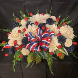 Red, white, and blue floral arrangement with a ribbon bow