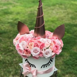 Unicorn-shaped floral arrangement with pink roses and a ribbon bow