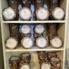 Shelves of wicker-wrapped candles with round labeled lids