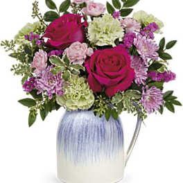 Bouquet of pink and white flowers in a blue ceramic vase
