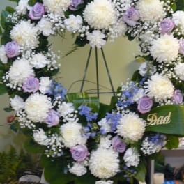 Heart-shaped floral wreath with white mums, lavender roses, and blue accents