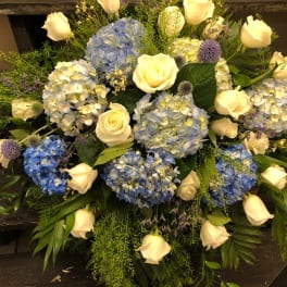 Blue hydrangeas and white roses arranged in a low bouquet