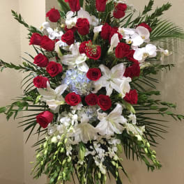 Standing floral spray with red roses, white lilies, and orchids
