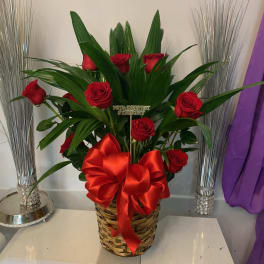 Red roses in a woven basket with a large red bow