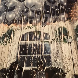 Cluster of black and silver balloons with long hanging ribbons