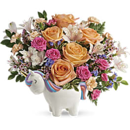 Bouquet of peach and pink roses in a unicorn-shaped vase