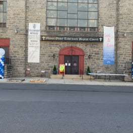 Church entrance with blue and white balloon columns and banners