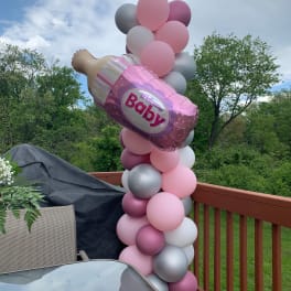 Pink and silver balloon column with a baby bottle balloon