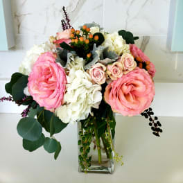 Pink roses and white hydrangeas in a clear glass vase