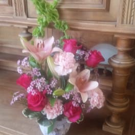 Pink and white floral arrangement in a decorative vase