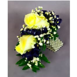 Yellow rose corsage with baby's breath, navy ribbon, and pearl accents