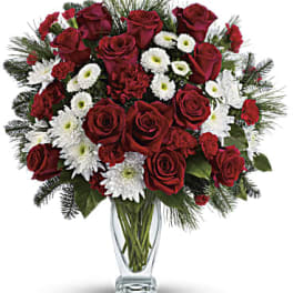 Red roses and white daisies in a clear glass vase
