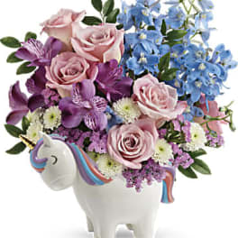 Pink and blue flowers arranged in a unicorn-shaped vase