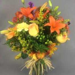 Bouquet of orange lilies and yellow roses in a glass vase
