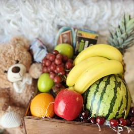 Gift basket with fruit, chocolates, and a teddy bear