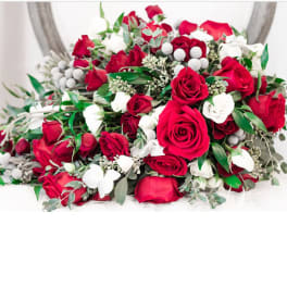 Bouquet of red and white roses with greenery and white berry accents