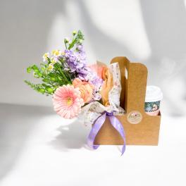 Small pastel flower bouquet and to-go cup in a brown cardboard drink carrier with ribbon