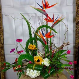 Tall tropical floral arrangement with bird-of-paradise and sunflowers