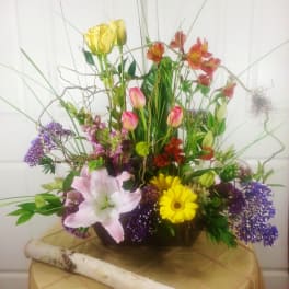 Tall mixed bouquet with lilies, tulips, daisies, and purple filler flowers