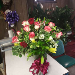 Bouquet of red and white roses with lilies in a glass vase