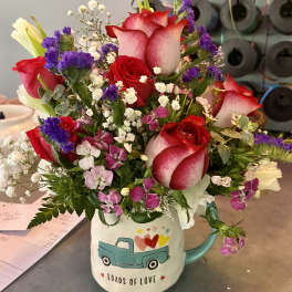 Bouquet of red and white roses in a mug with a truck design