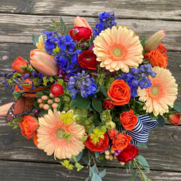 Colorful bouquet with gerbera daisies, roses, and blue flowers