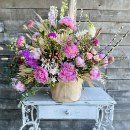 Pink and purple mixed bouquet in a wooden vase