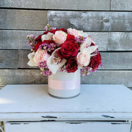 Bouquet of red and pale pink roses in a white hat box