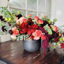 Mixed bouquet of red and pink roses in a gray vase