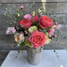 Pink and peach roses arranged in a decorative vase