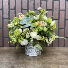 Mixed floral arrangement in a birch-style container with a blue succulent centerpiece