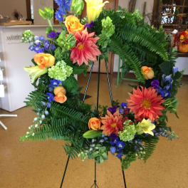 Colorful floral wreath on a black easel stand