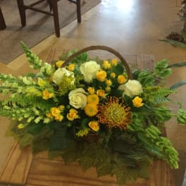 Basket arrangement of yellow and white flowers with greenery